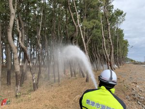 消防団による防風林への放水